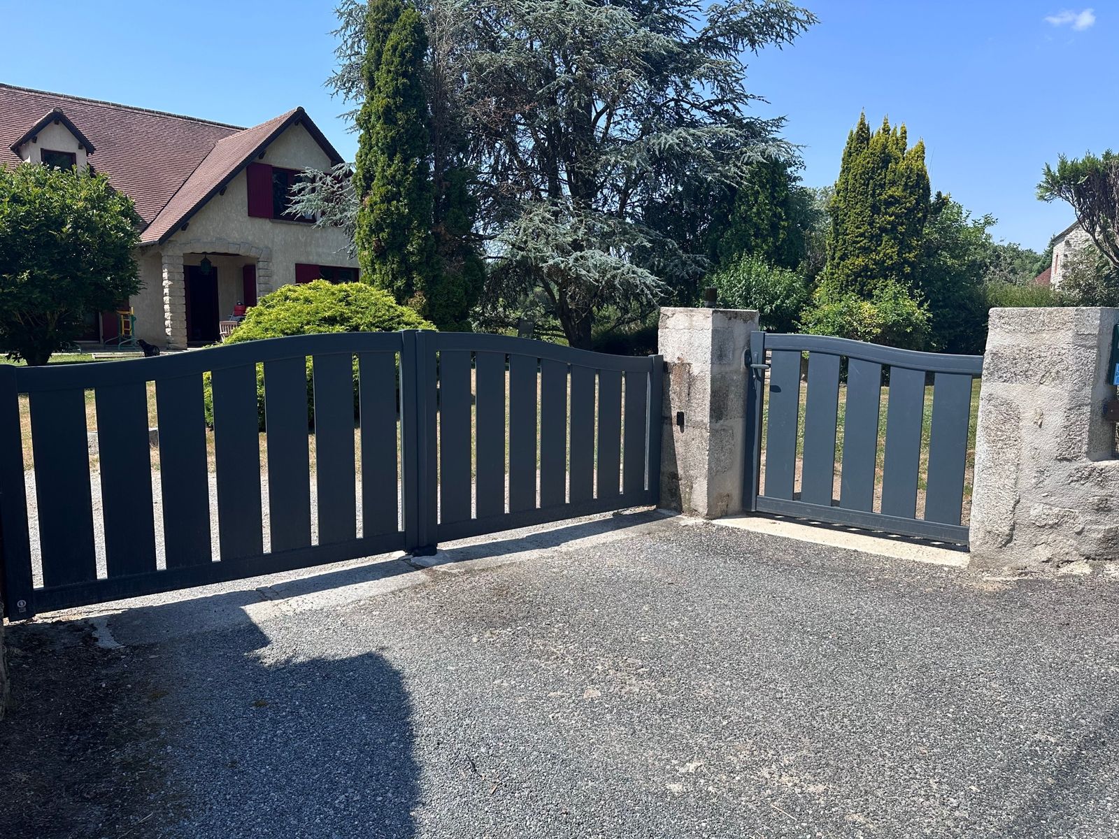 Portail et portillon gris anthracite entre piliers en pierre